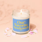 Candle in glass jar with blue label reading "Our Favorite Newlyweds VOWED".
