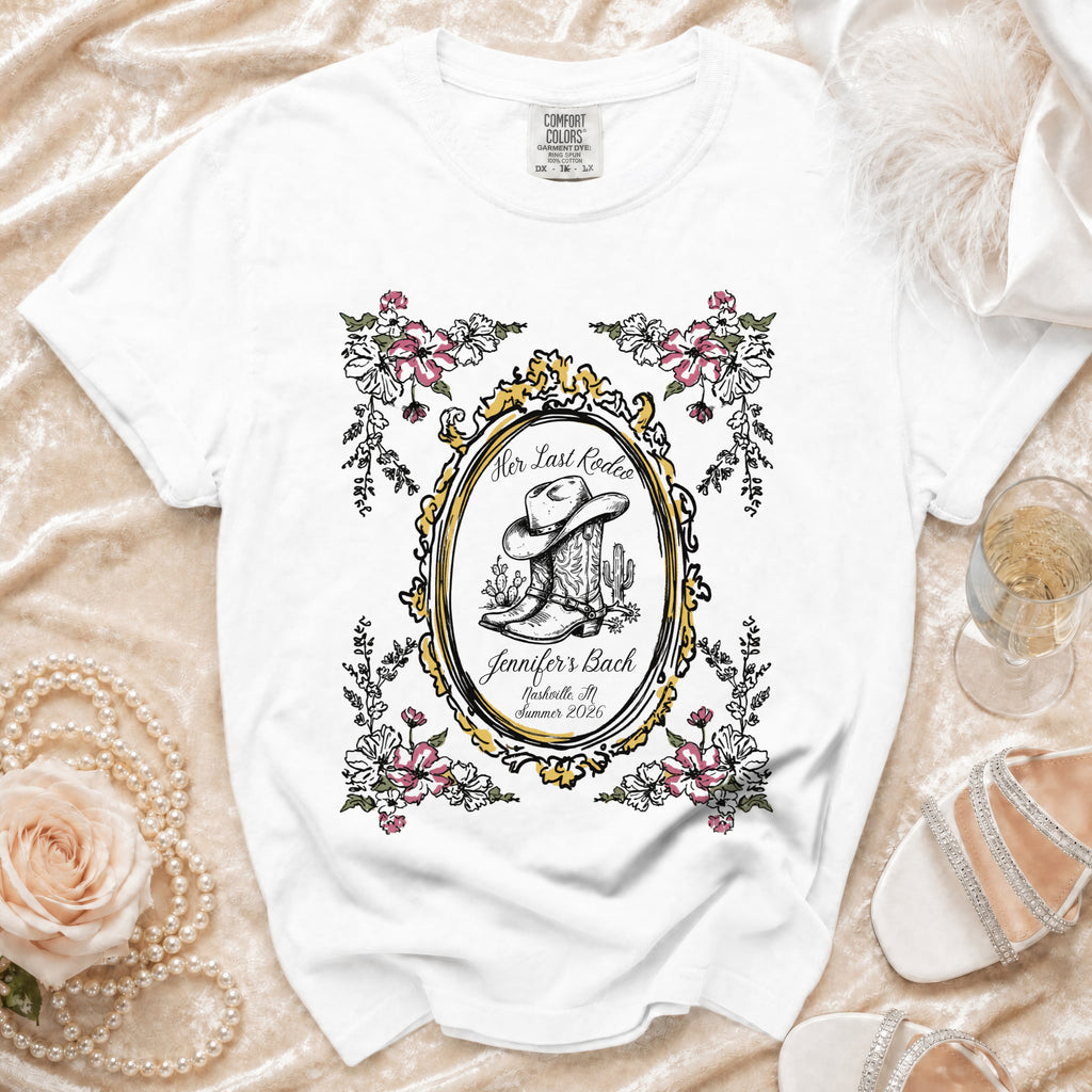 White t-shirt with "Her Last Rodeo" and bachelorette details in an oval frame.