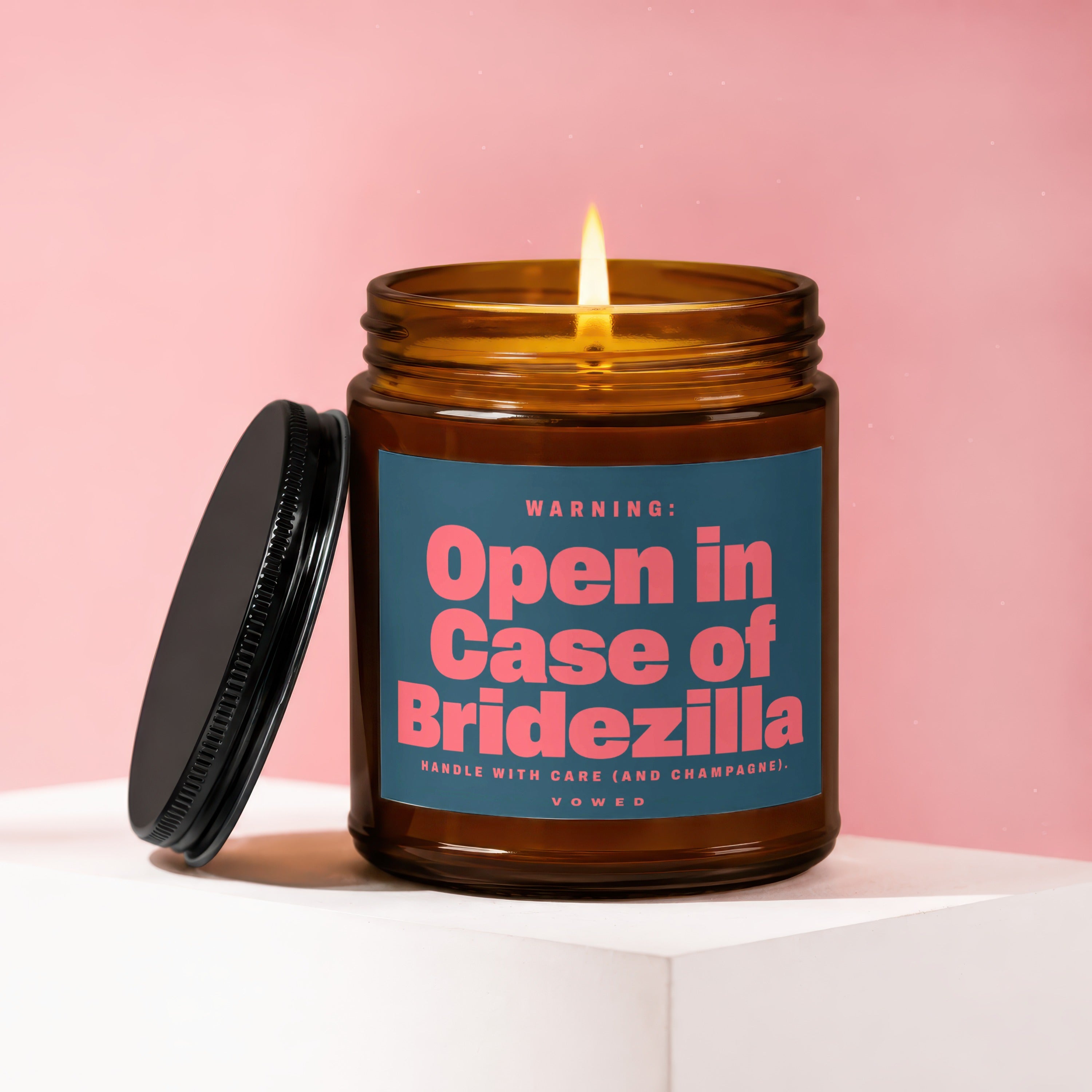 Amber jar candle with lit flame and black lid, reads "Open in Case of Bridezilla."
