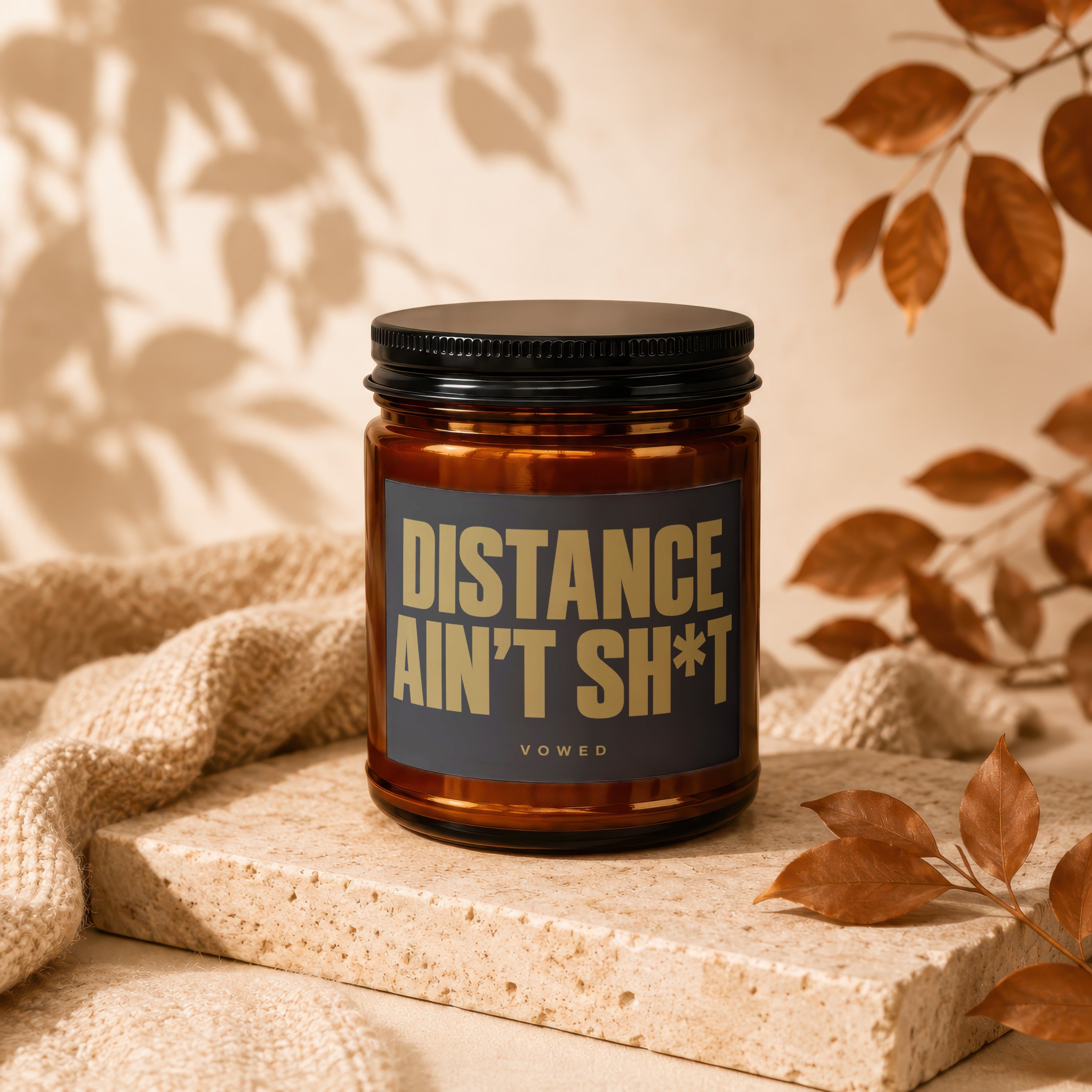 Amber jar candle with "DISTANCE AIN'T SH*T" text on label.