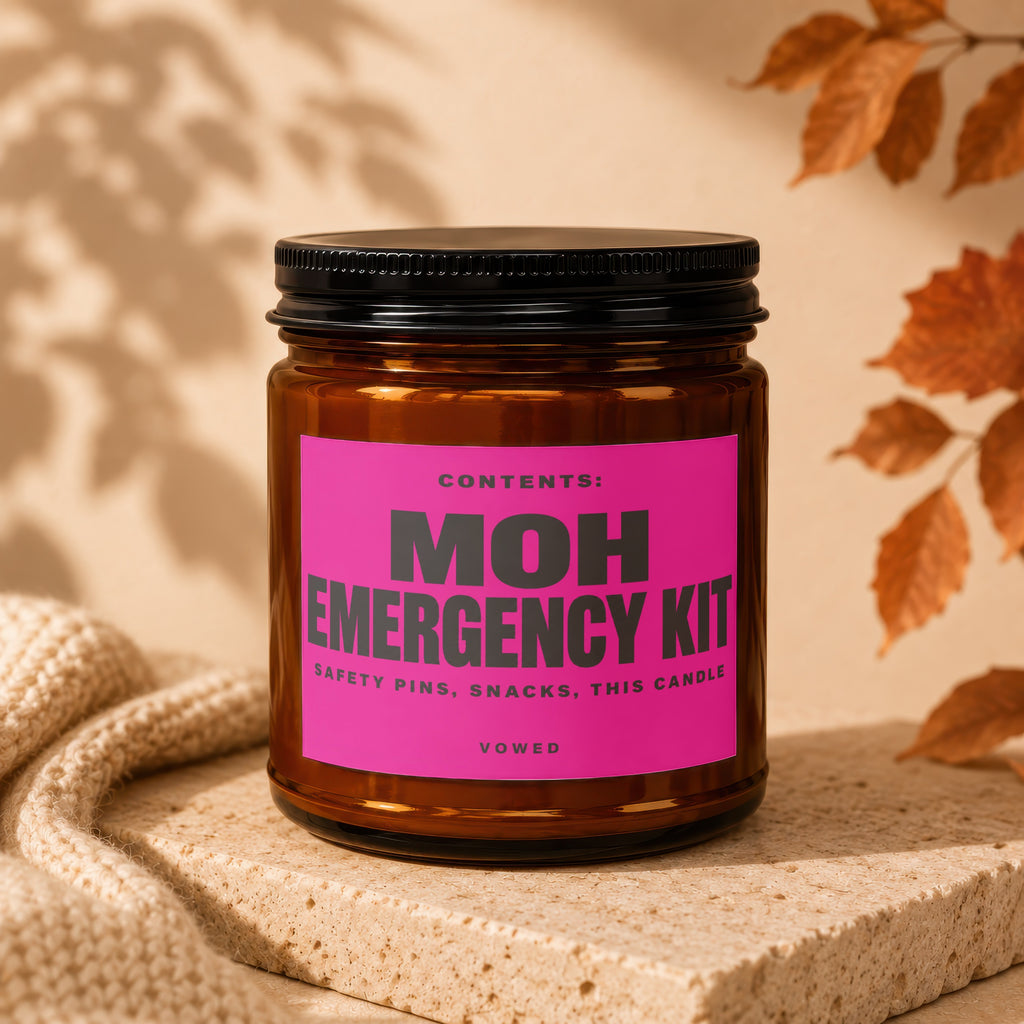 Glass jar with a pink label that says MOH EMERGENCY KIT, safety pins, snacks, this candle.