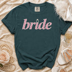 Teal t-shirt with "bride" text in pink polka dots and diamond ring graphic.