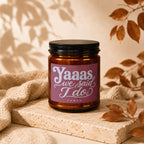 Amber jar candle with pink label reading "Yaaas we said I do" and "VOWED".