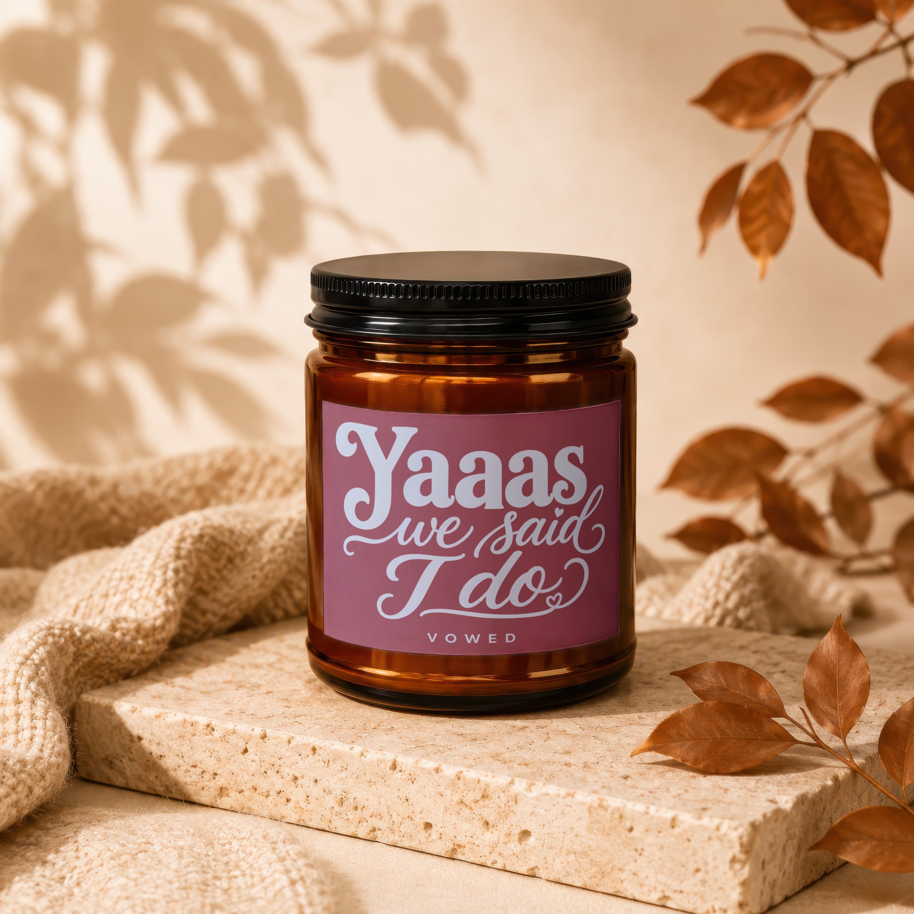 Amber jar candle with pink label reading "Yaaas we said I do" and "VOWED".