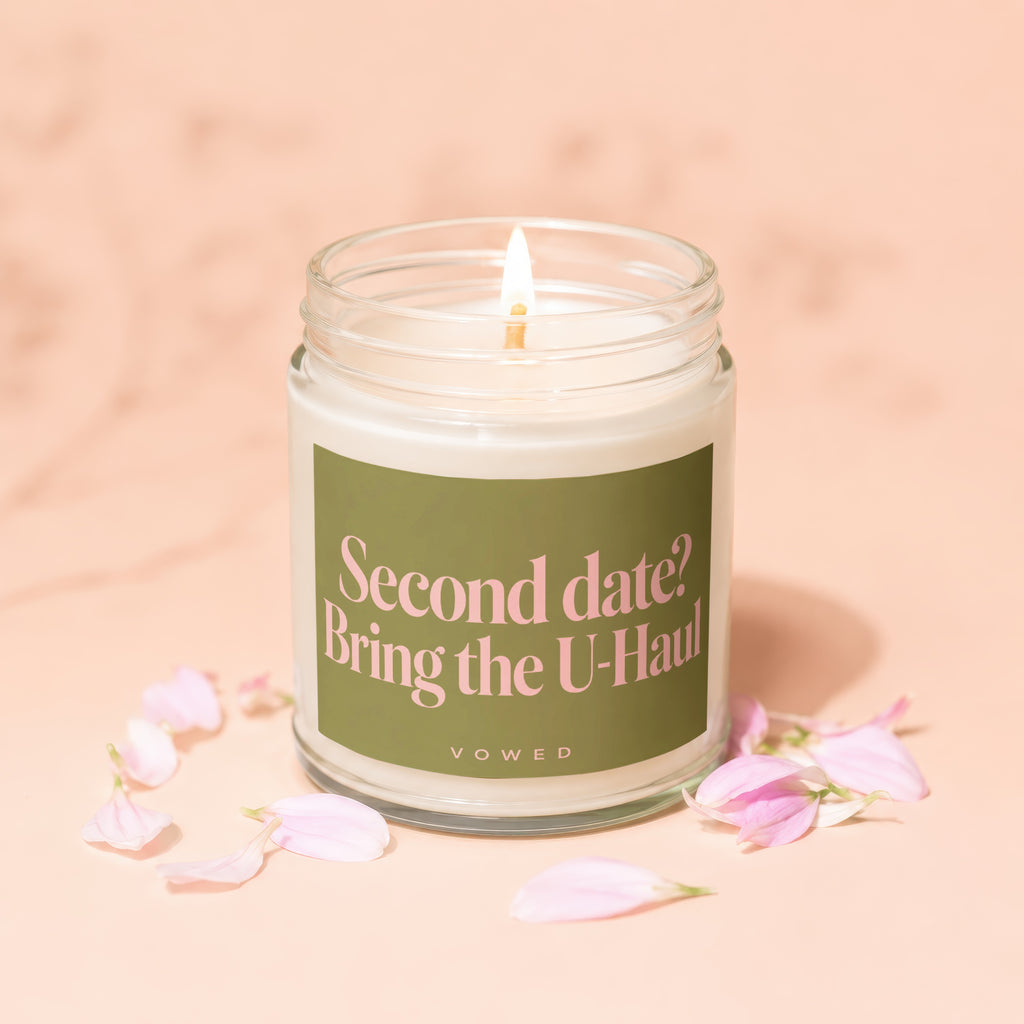 Glass jar candle with green label reading "Second date? Bring the U-Haul"