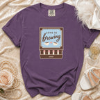 Purple t-shirt with "Love is brewing" text and coffee cups graphic.
