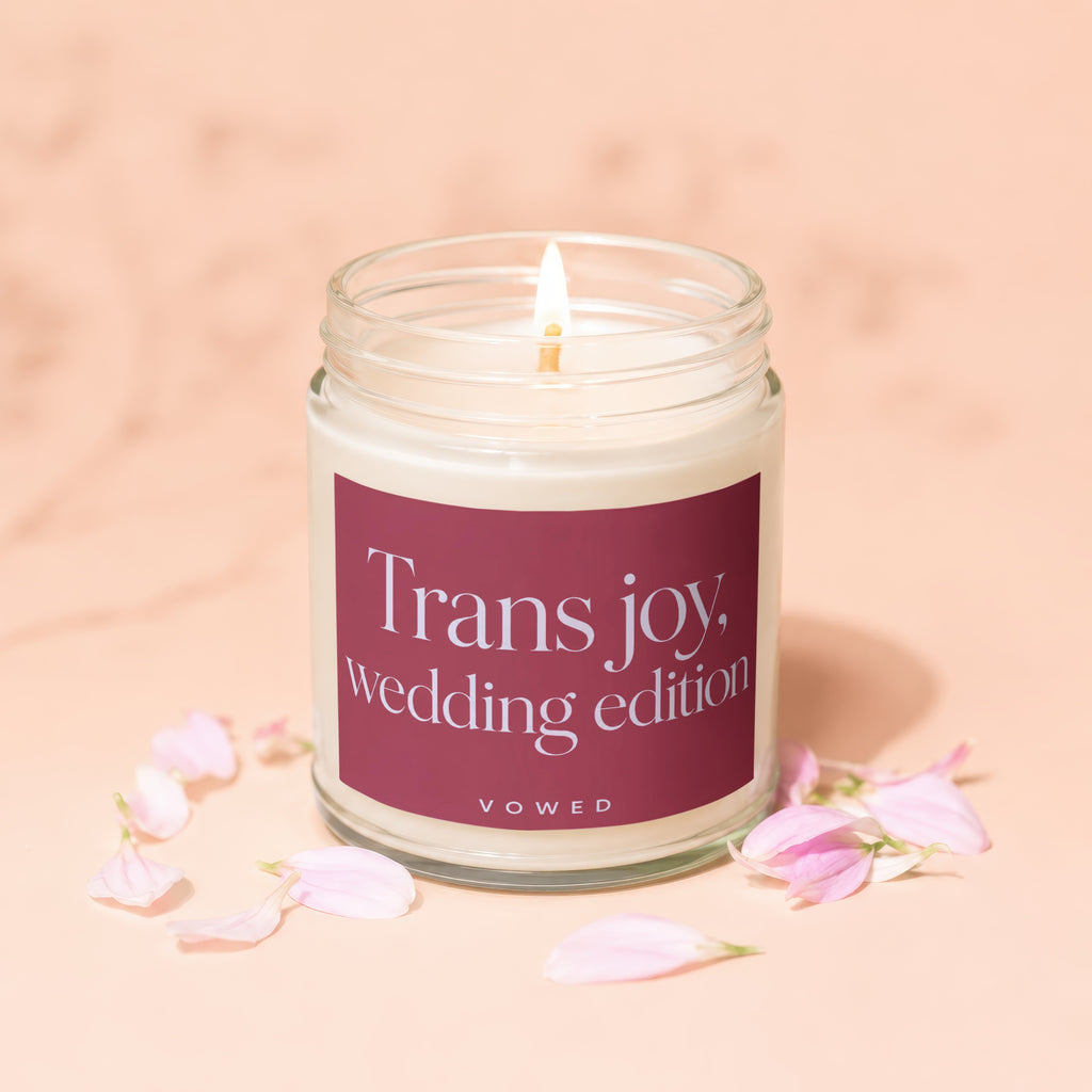 A lit candle labeled "Trans joy, wedding edition" surrounded by pink petals.