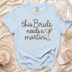 Light blue t-shirt with "This Bride needs a martini" text and martini glass design.