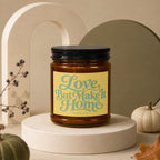 Amber candle with yellow label saying "Love, But Make It Home" and "vowed".