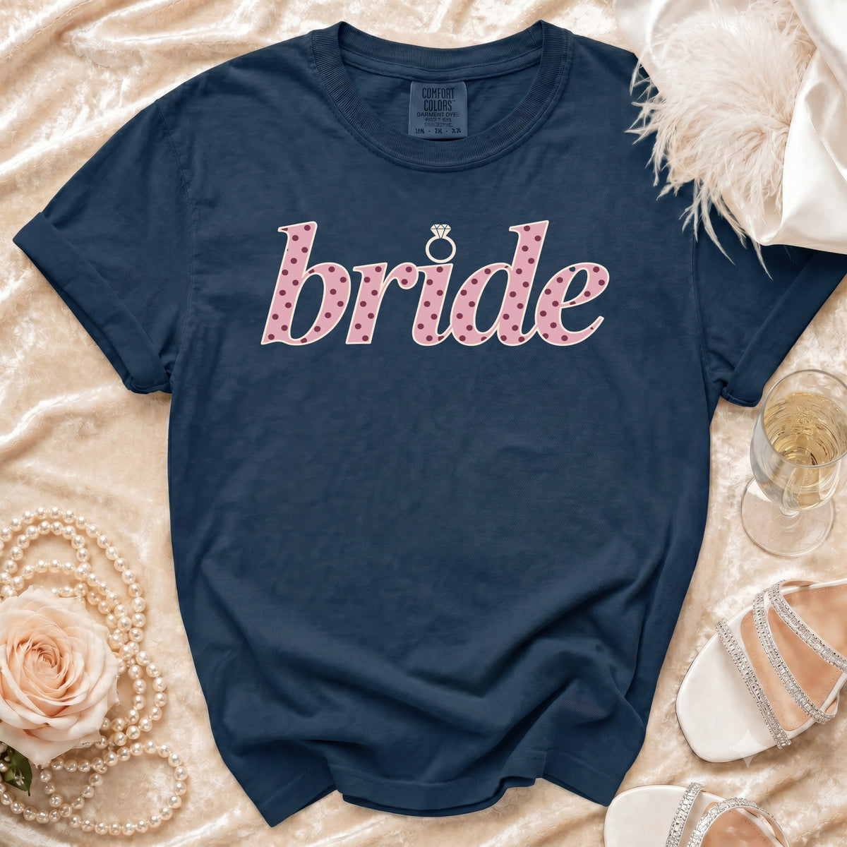 Navy t-shirt with pink polka dot "bride" text and a diamond ring.