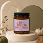 Amber jar candle with black lid, label reads "Two hearts, one U-Haul".