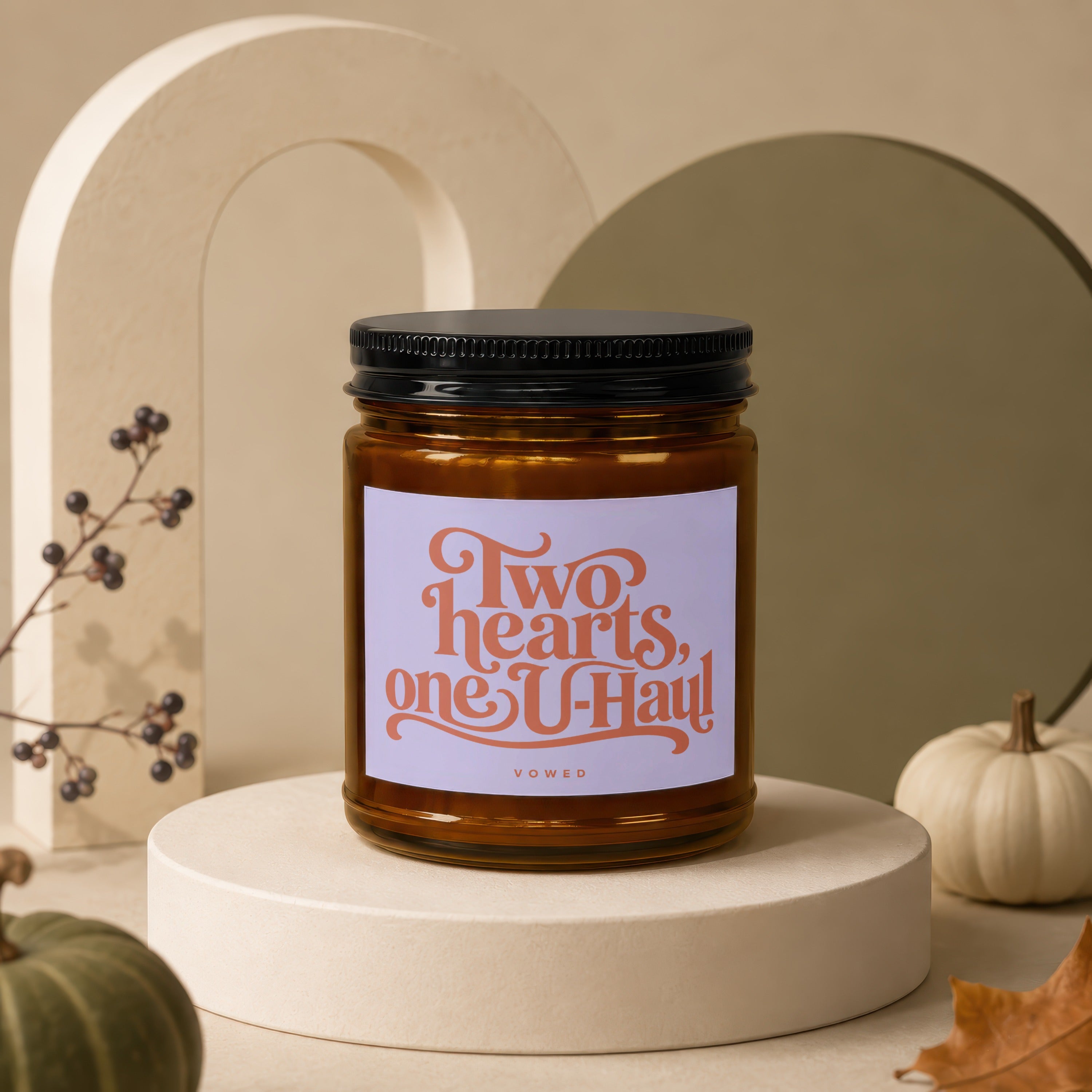 Amber jar candle with black lid, label reads "Two hearts, one U-Haul".