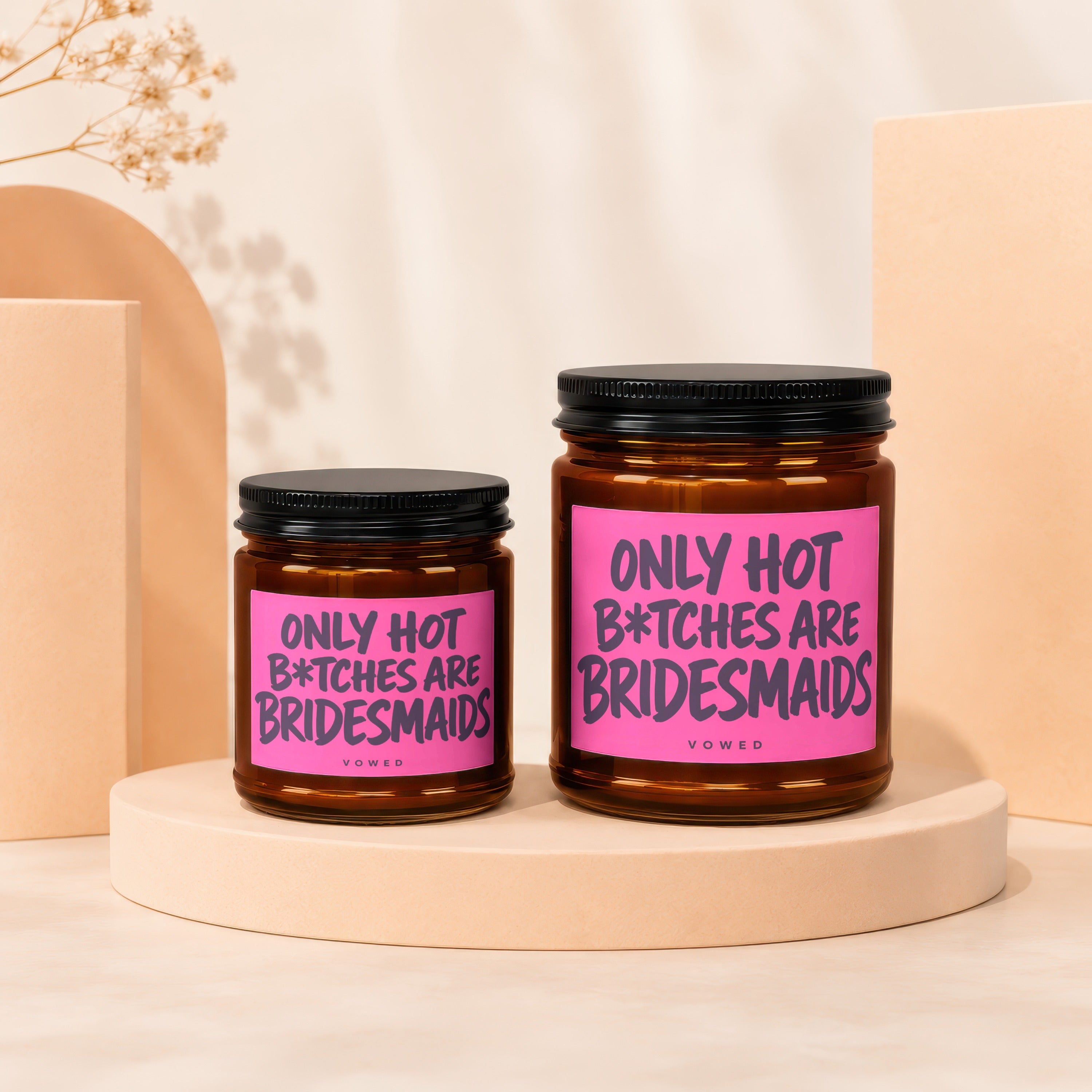 Two amber glass candles with pink labels reading "ONLY HOT B*TCHES ARE BRIDESMAIDS VOWED".