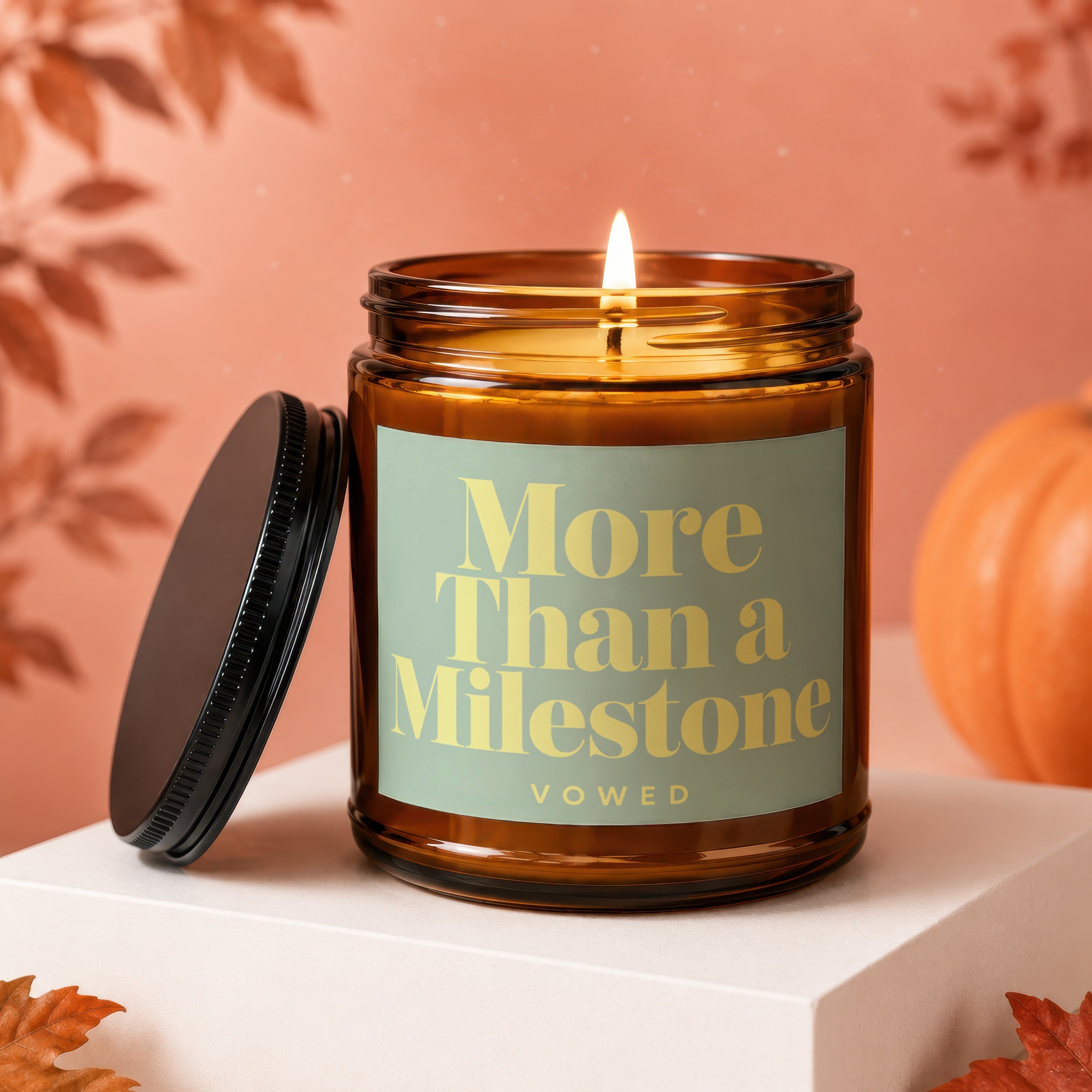 Lit amber glass candle with "More Than a Milestone" and "vowed" text.