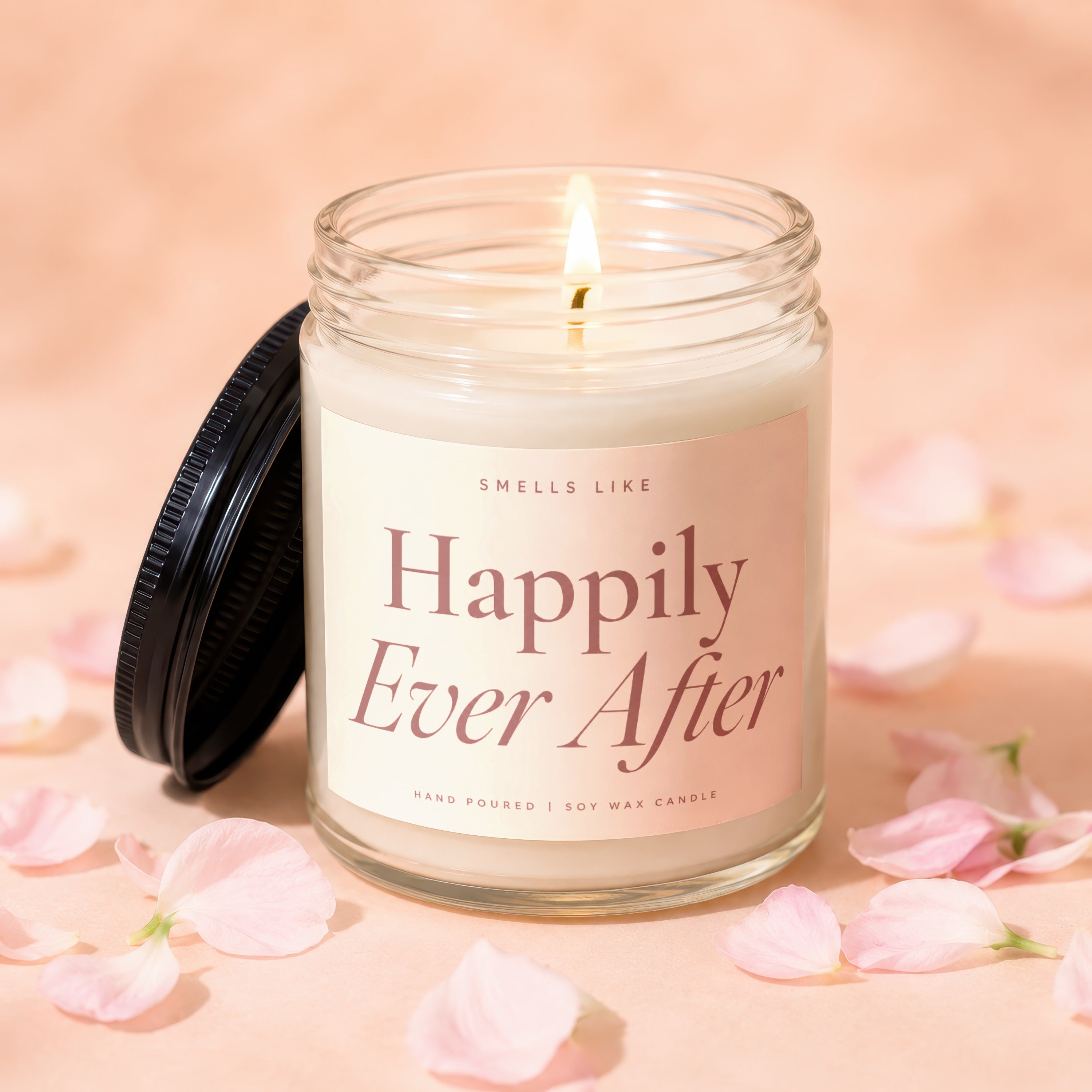 Lit soy wax candle in glass jar labeled "Happily Ever After" with lid.