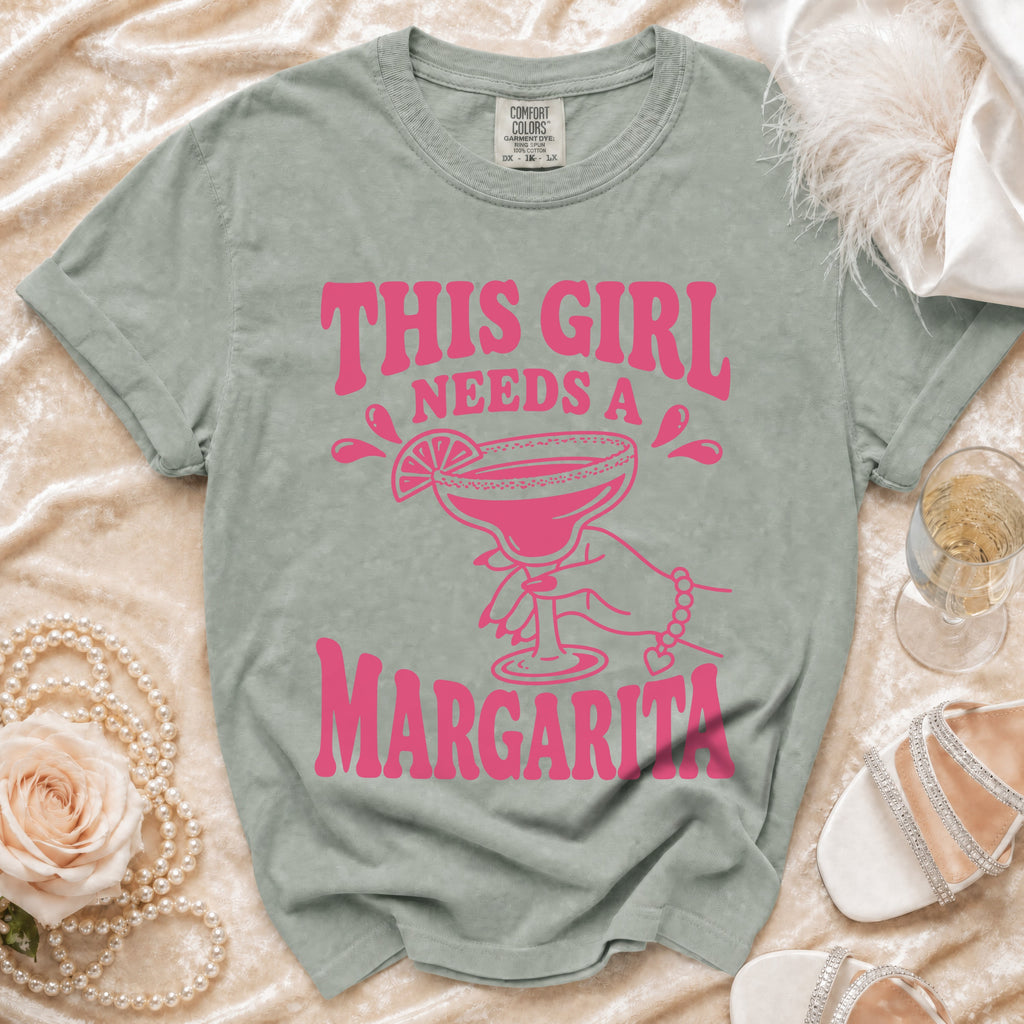 Green t-shirt with pink text and graphic: "THIS GIRL NEEDS A MARGARITA".