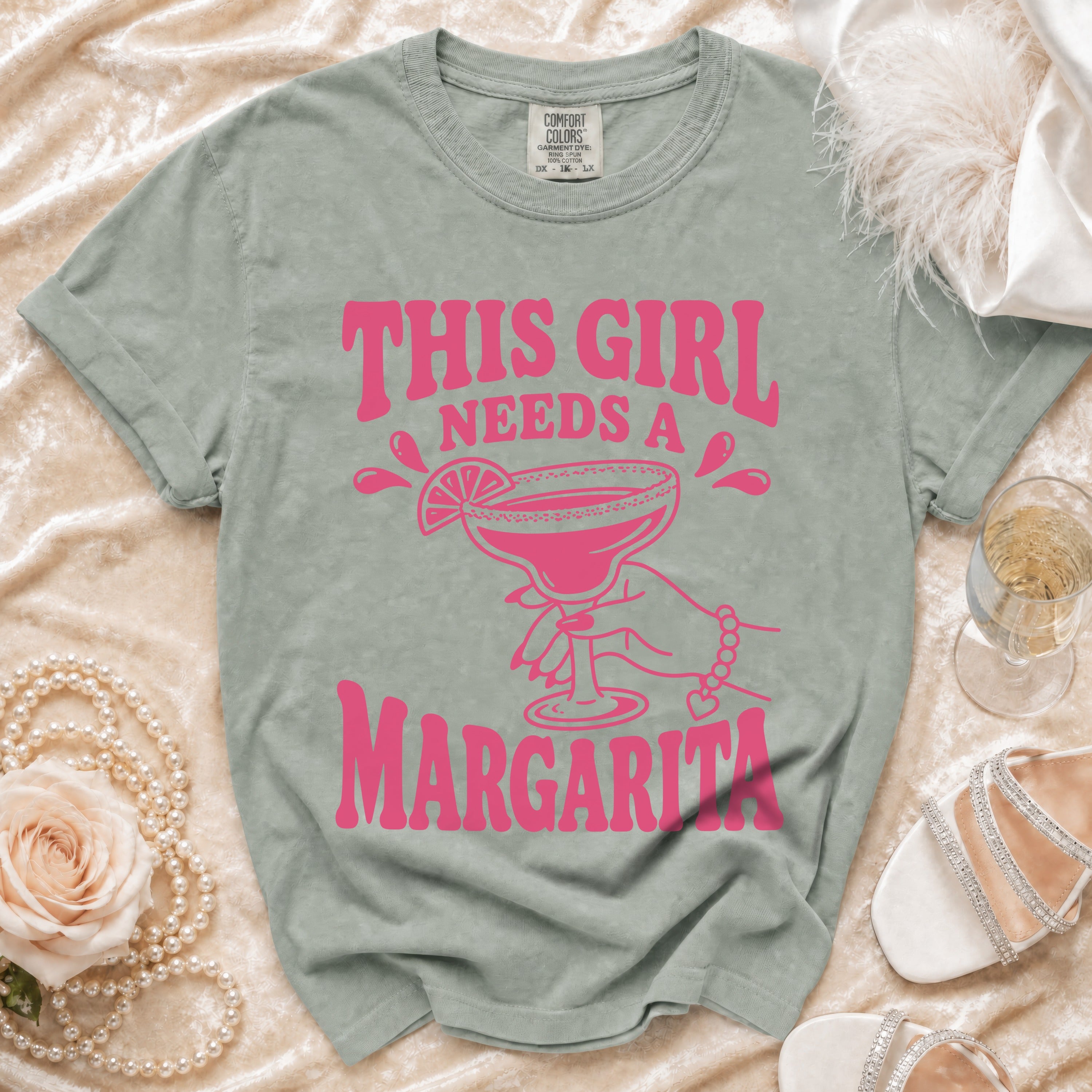 Green t-shirt with pink text and graphic: "THIS GIRL NEEDS A MARGARITA".