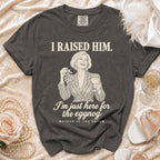 Charcoal gray t-shirt with an illustration of a woman holding mistletoe and eggnog, featuring text "I RAISED HIM. I'm just here for the eggnog, MOTHER OF THE GROOM".