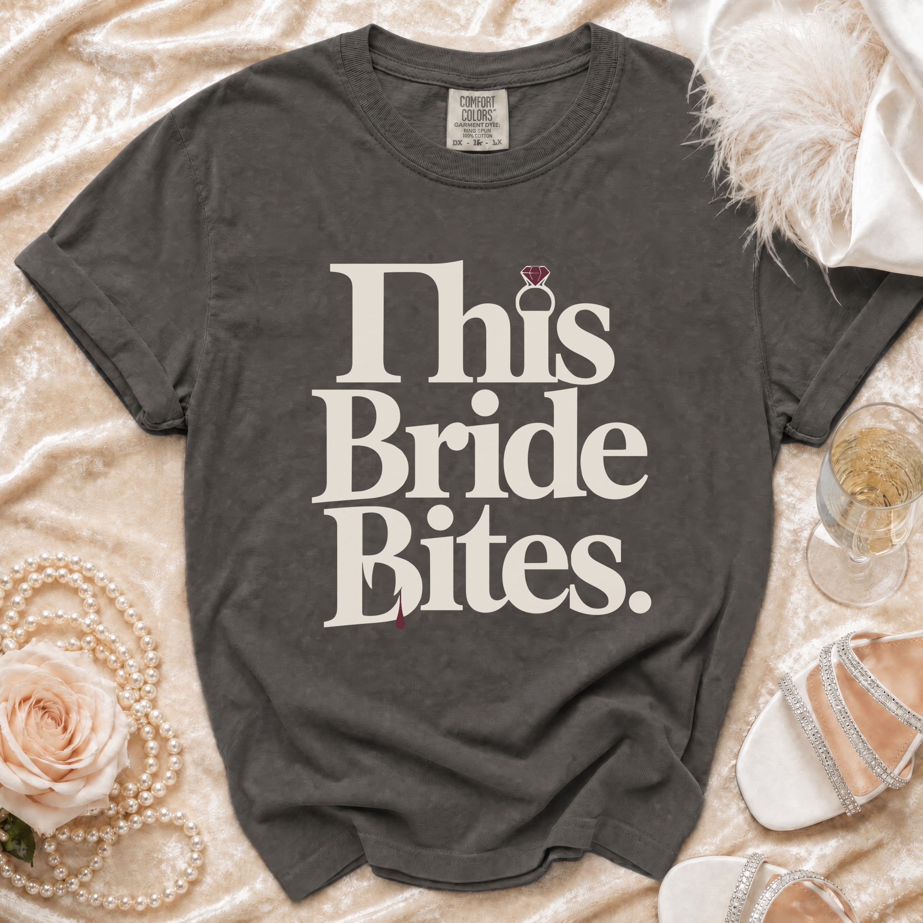 Grey t-shirt with "This Bride Bites" text, a diamond ring, and a red drop.