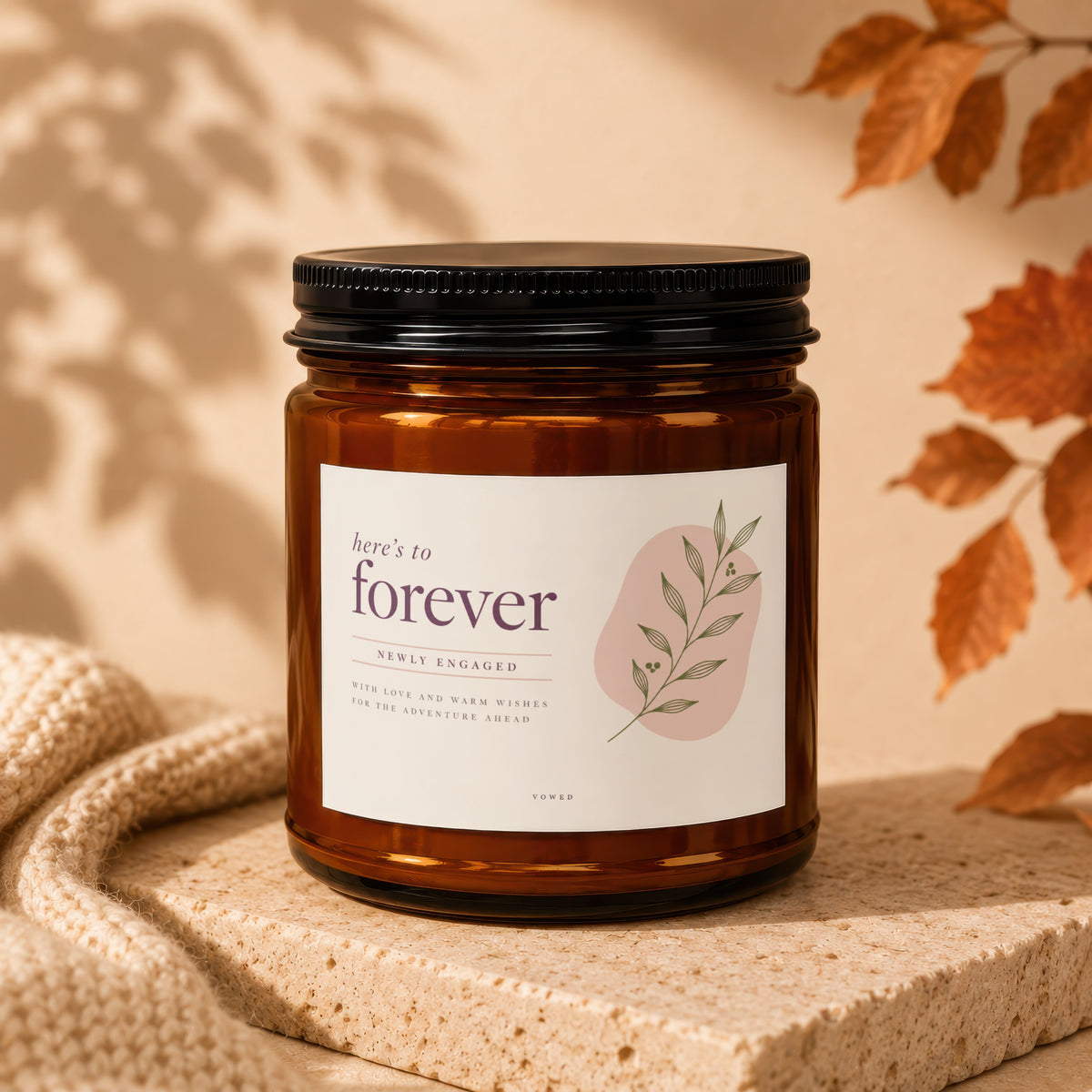Amber jar candle with "here's to forever" label for newly engaged couples.