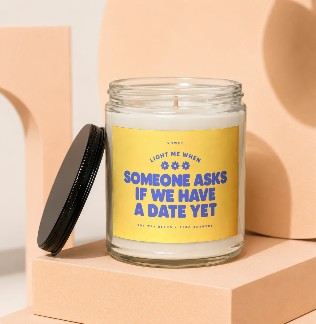 Glass jar candle with "Light Me When Someone Asks If We Have A Date Yet" text.