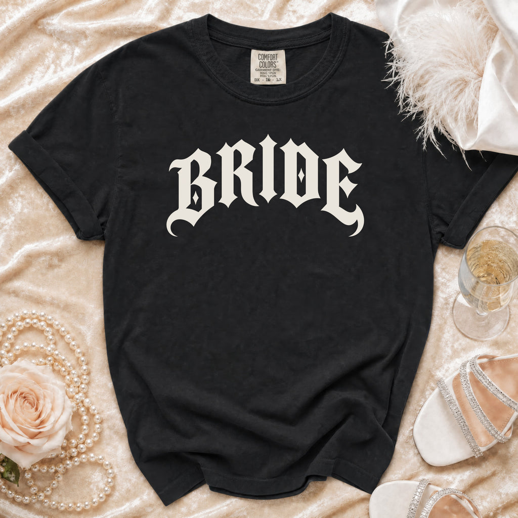 Black t-shirt with "BRIDE" in Gothic font, styled with pearls, rose, and heels.