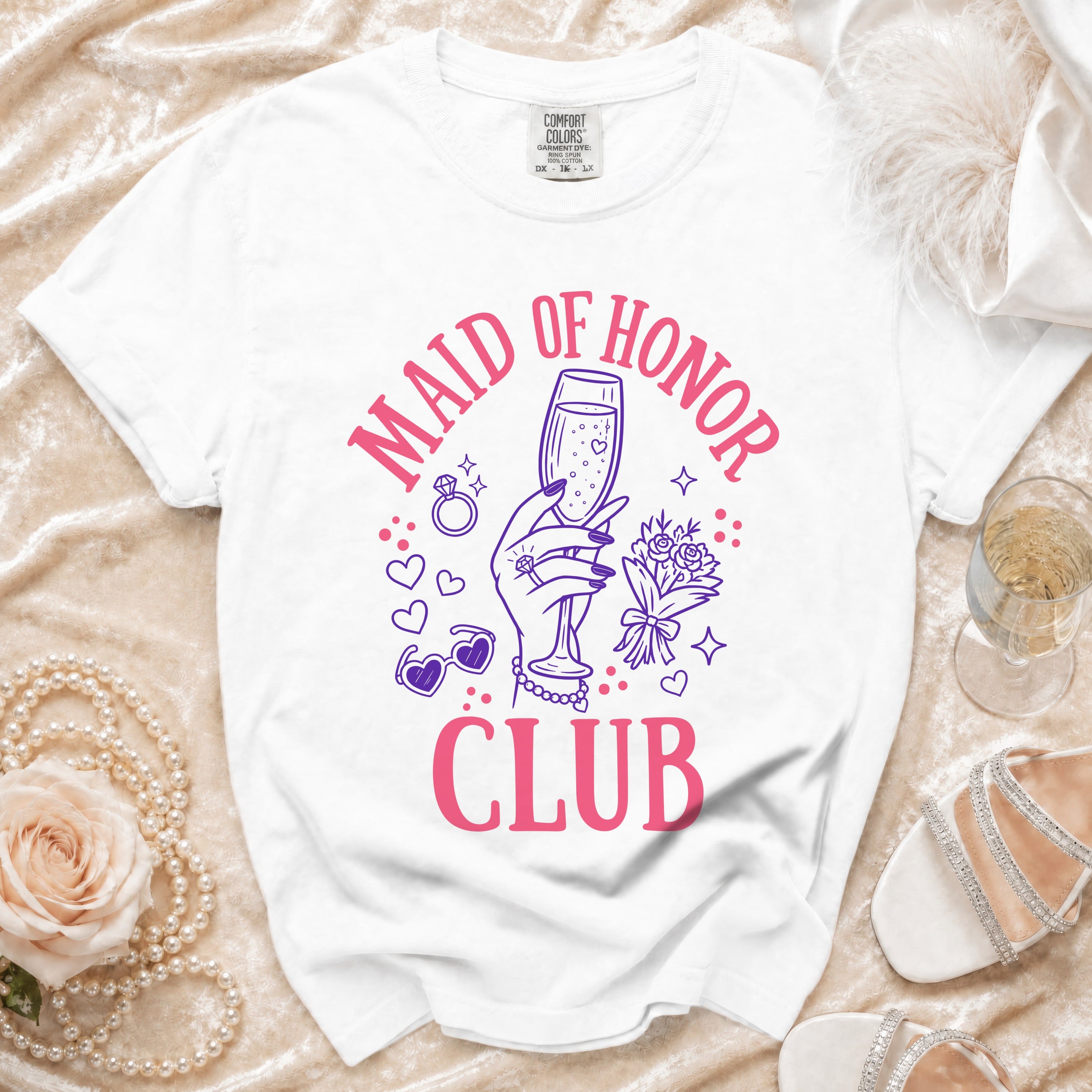 White t-shirt with "Maid of Honor Club" text and graphic of hand holding champagne.