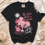 Black t-shirt with a tropical margarita, palm trees, and text: "This Girl Needs a Margarita Bride's Getaway Club Cheers to Forever".