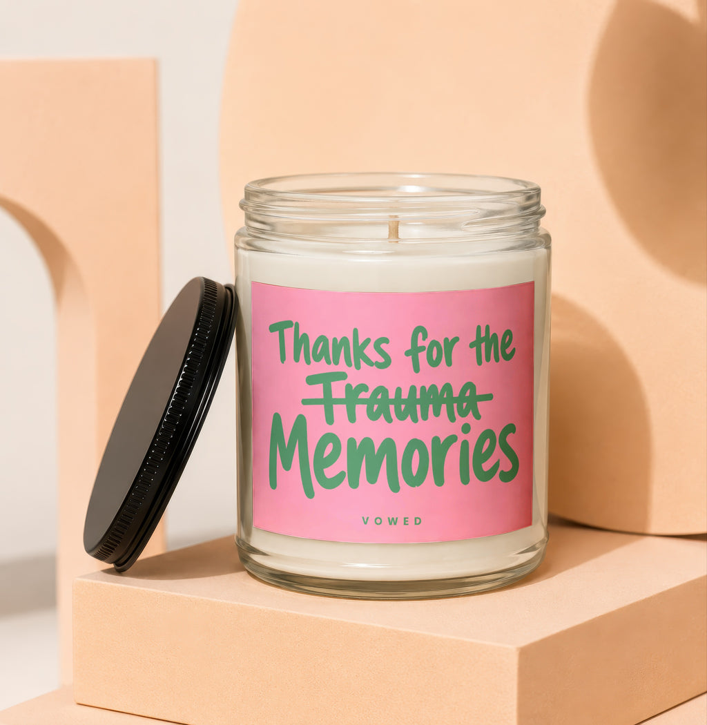 Glass candle with pink label saying "Thanks for the Trauma Memories" and "vowed".