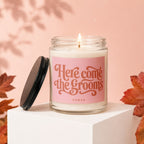 Glass candle with "Here Come the Grooms" and "Vowed" text on a pink label.