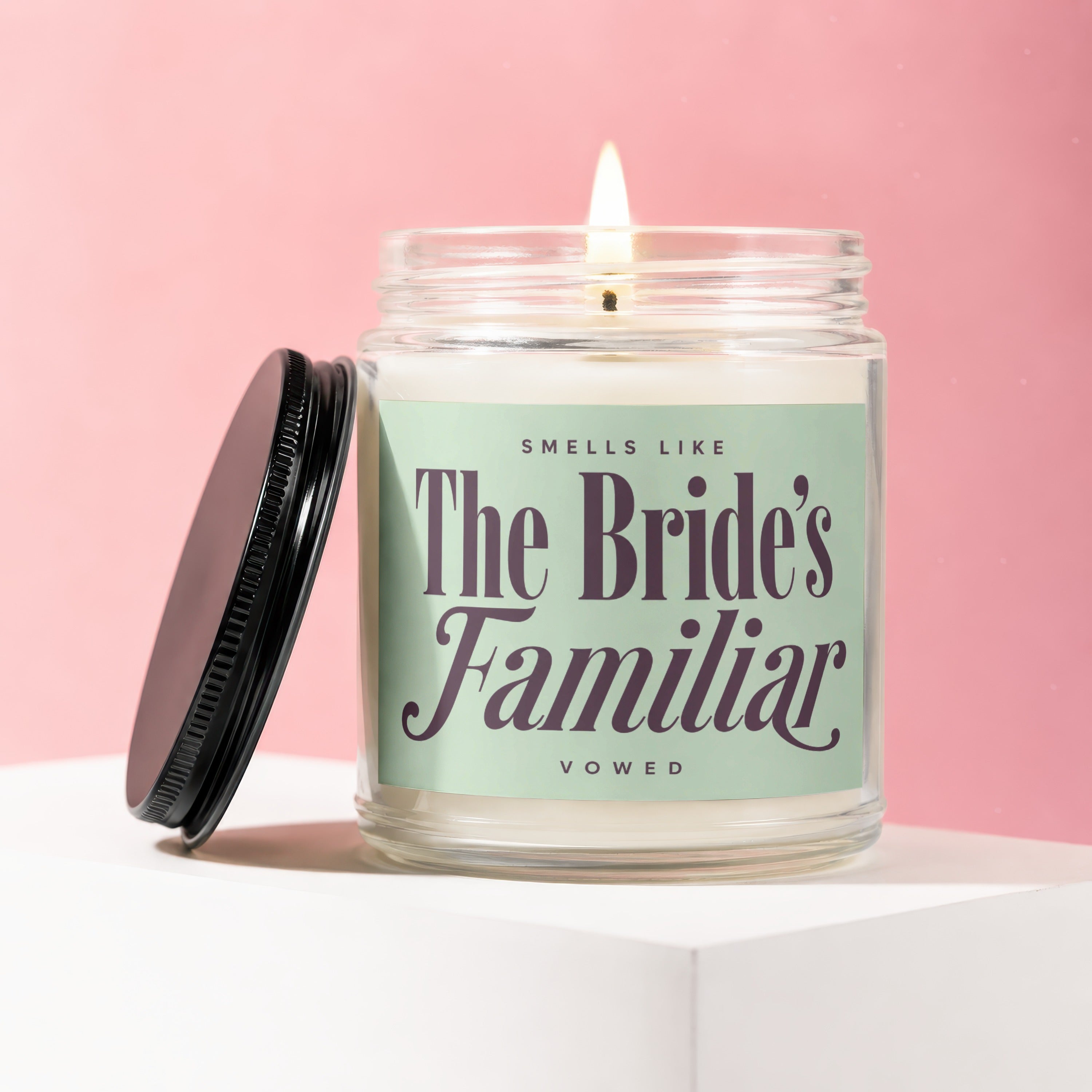 Candle with a lit wick labeled "Smells Like The Bride's Familiar"