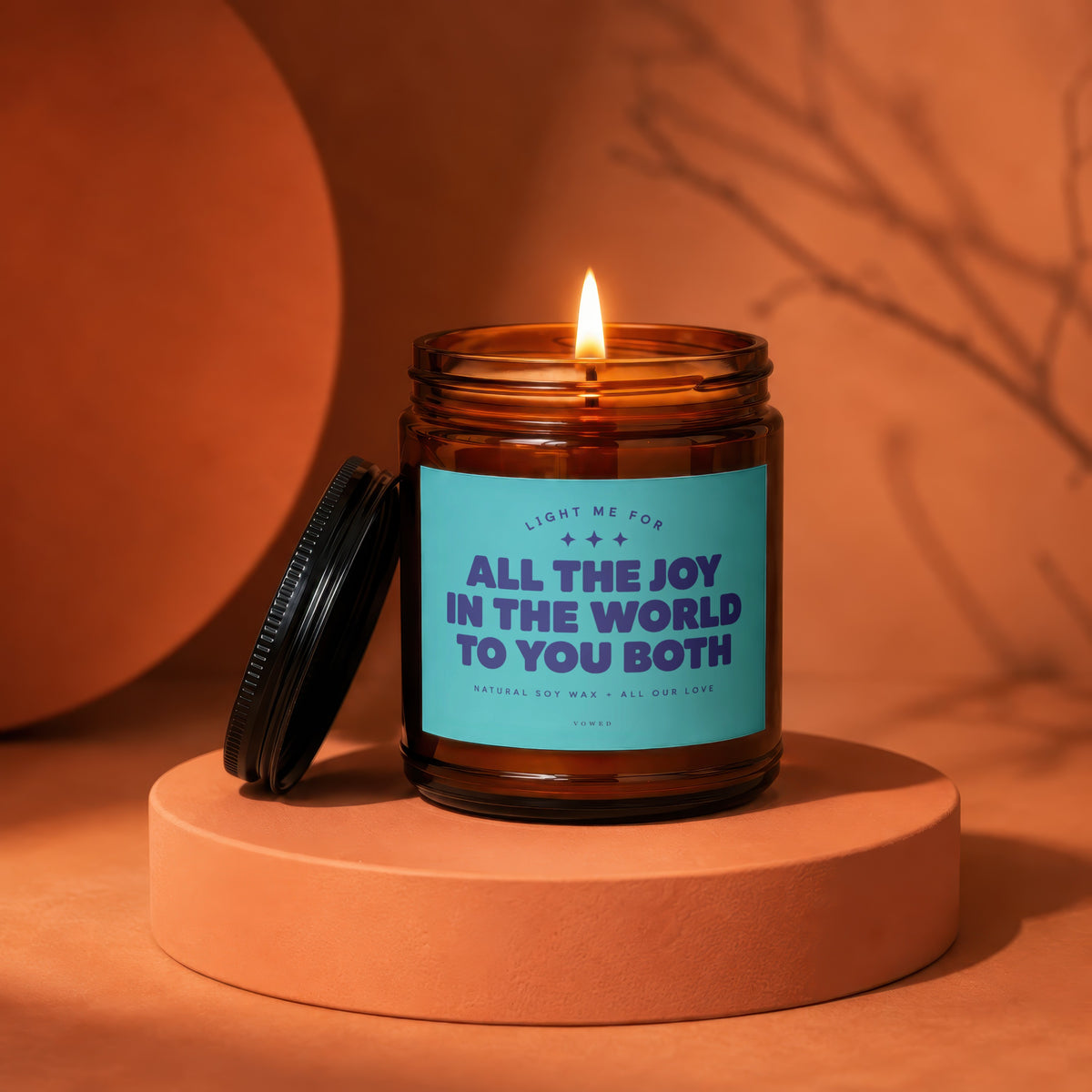Amber jar candle with teal label reading "All the joy in the world to you both."