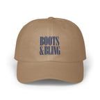 A tan dad hat with the text BOOTS & BLING embroidered in blue on the front.