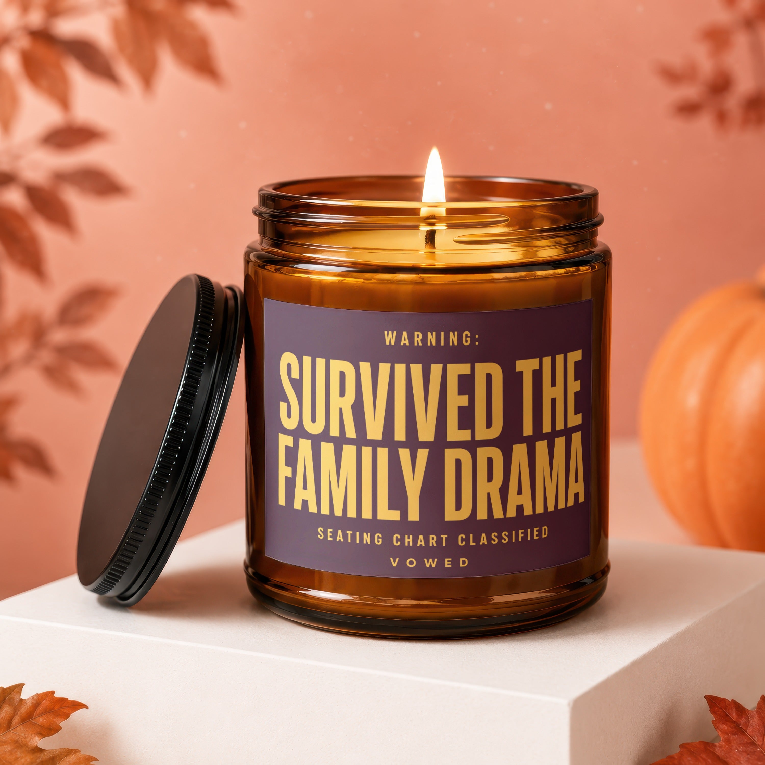 Lit amber candle with "Survived the Family Drama" text, featuring fall decor.