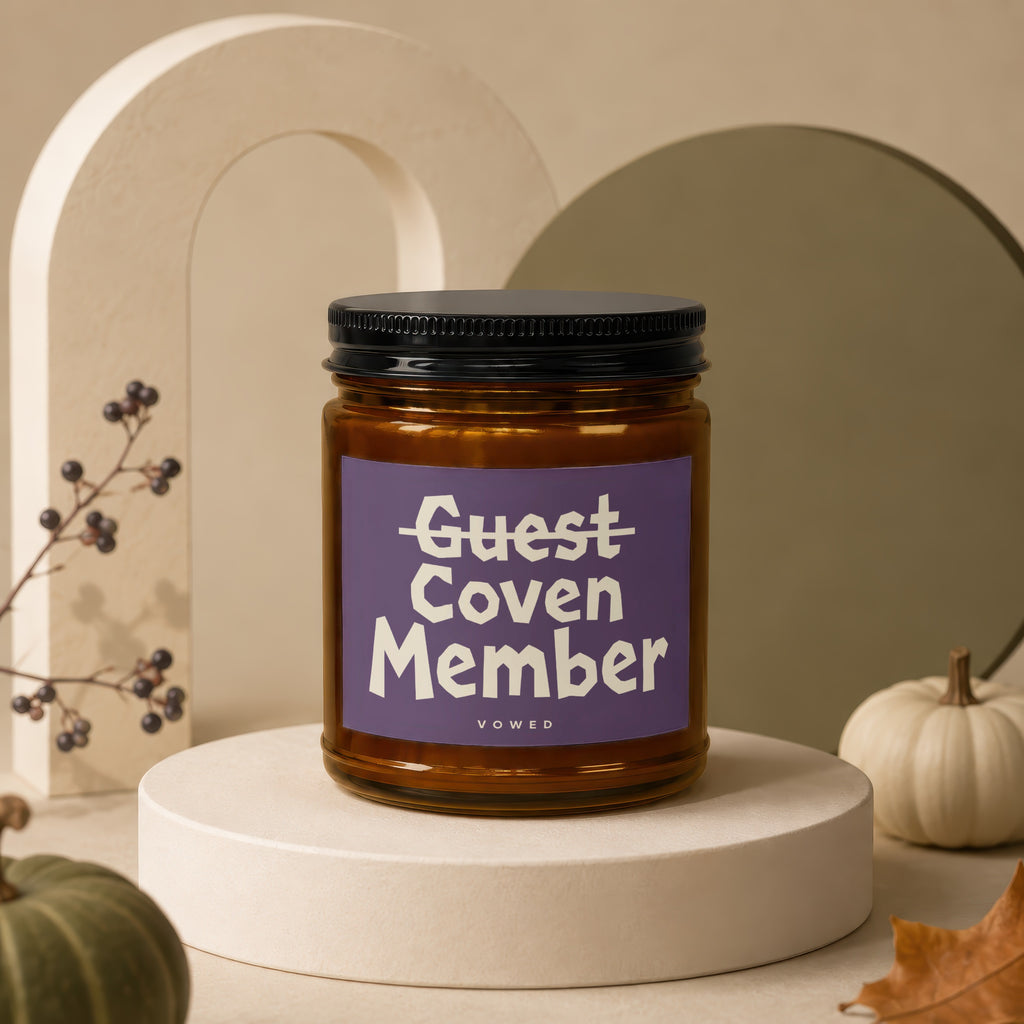 Amber jar candle with purple label reading "Guest Coven Member" and "vowed".