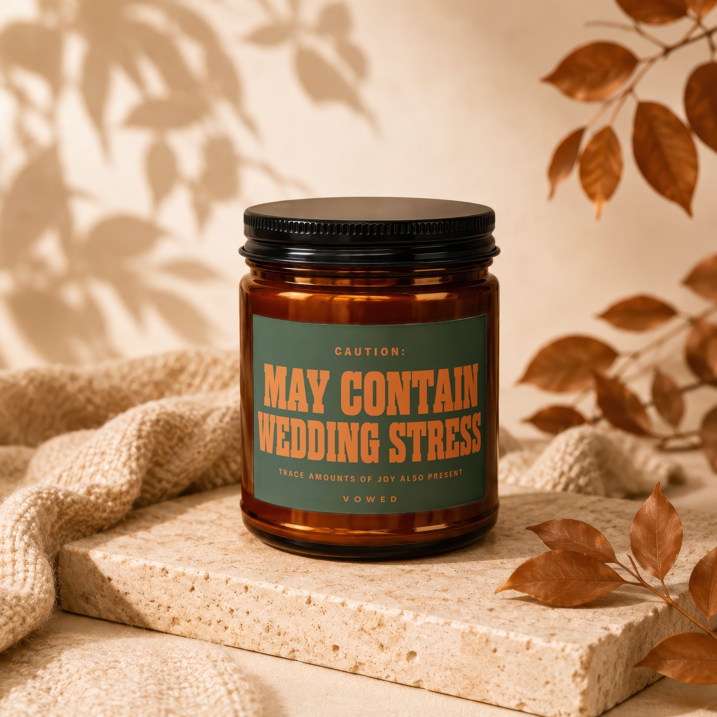 Amber candle with black lid and "May Contain Wedding Stress" label.