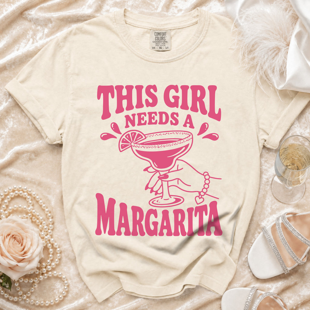 Cream t-shirt with pink graphic saying "THIS GIRL NEEDS A MARGARITA".