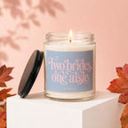 Candle with text "Two brides, one aisle" and "vowed" on a light blue label.