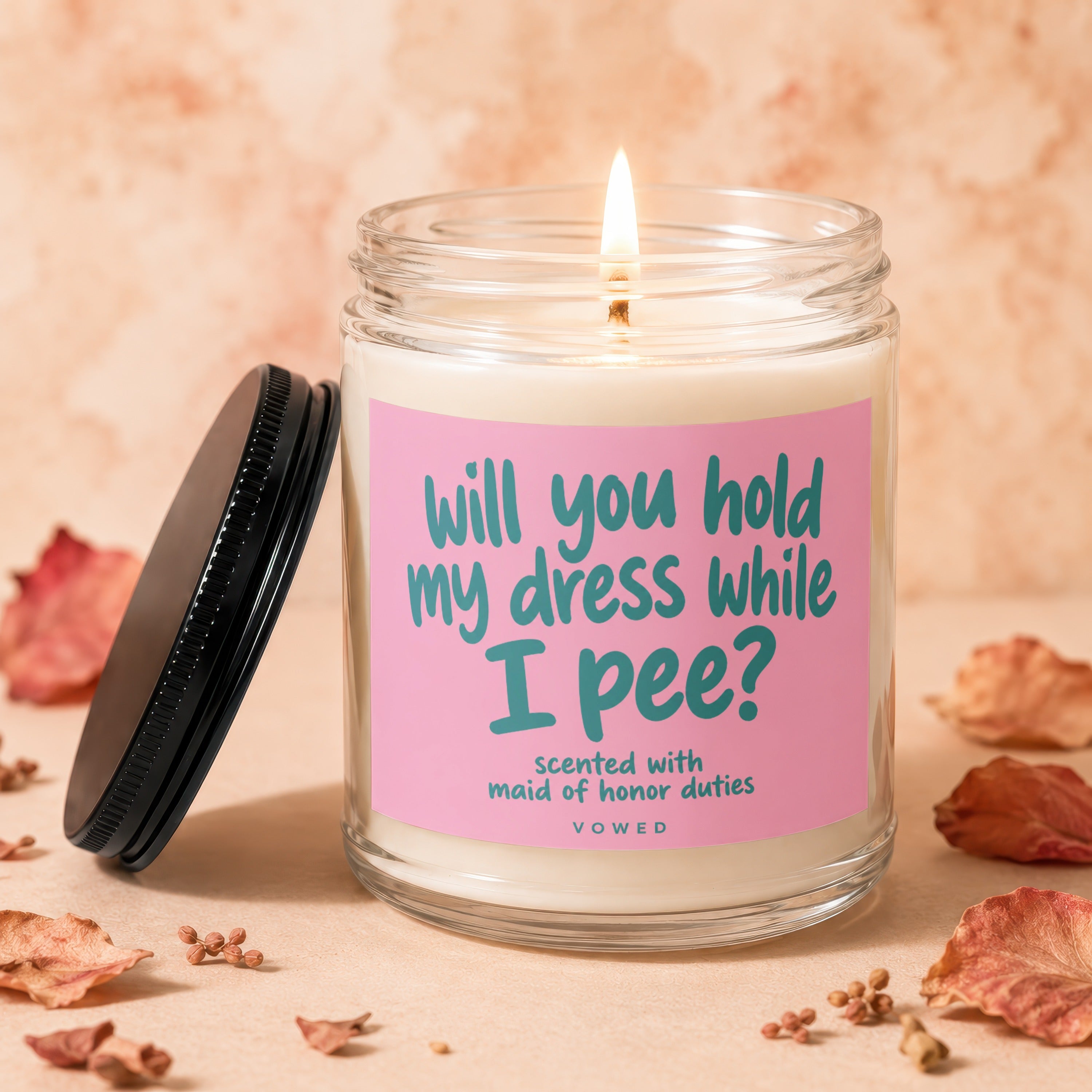 Candle with pink label asking "will you hold my dress while I pee?".
