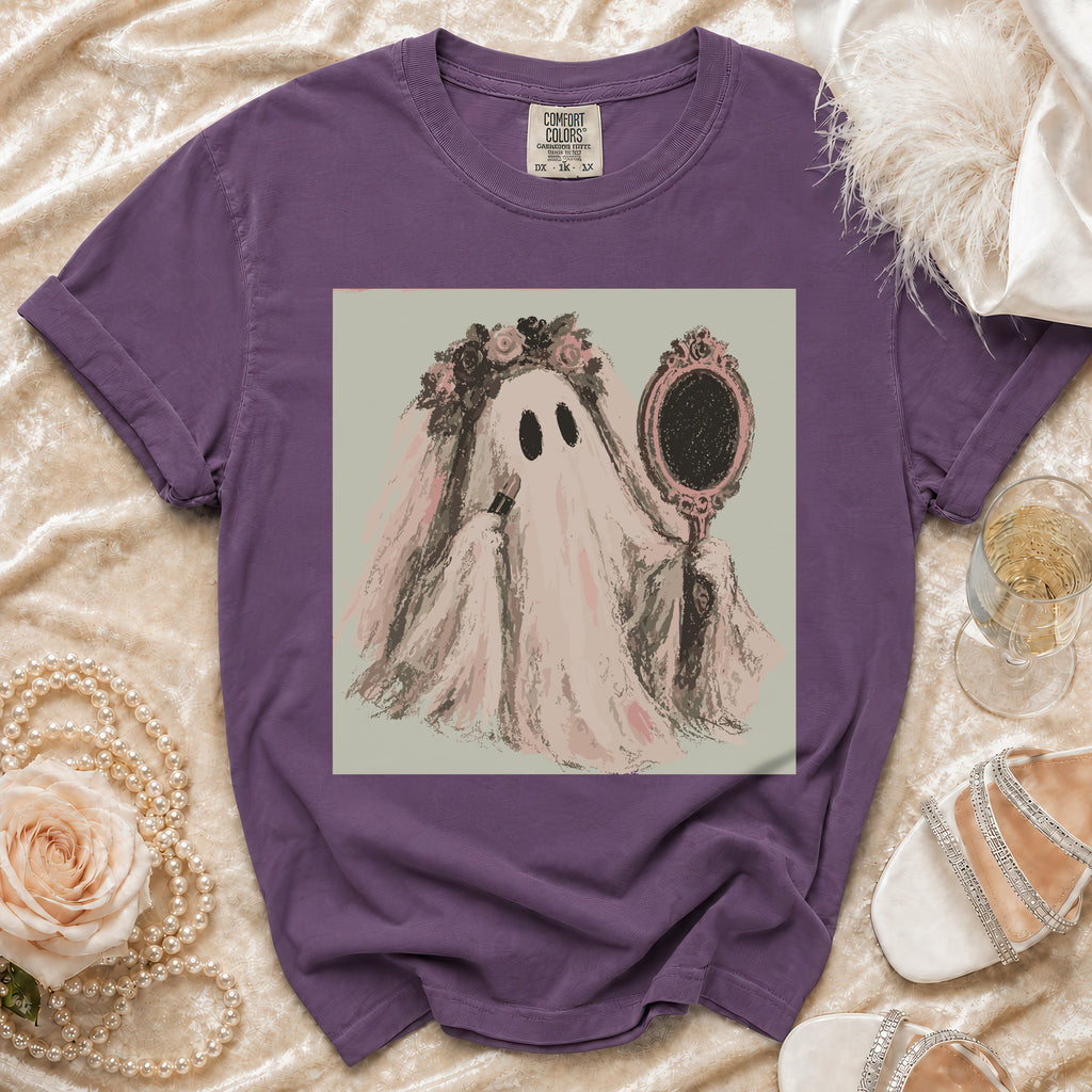 Purple t-shirt with a ghost in a veil applying lipstick in a mirror.