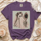 Purple t-shirt with a ghost in a veil applying lipstick in a mirror.
