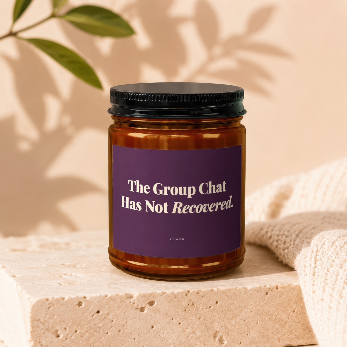 Amber jar candle with purple label reading "The Group Chat Has Not Recovered."