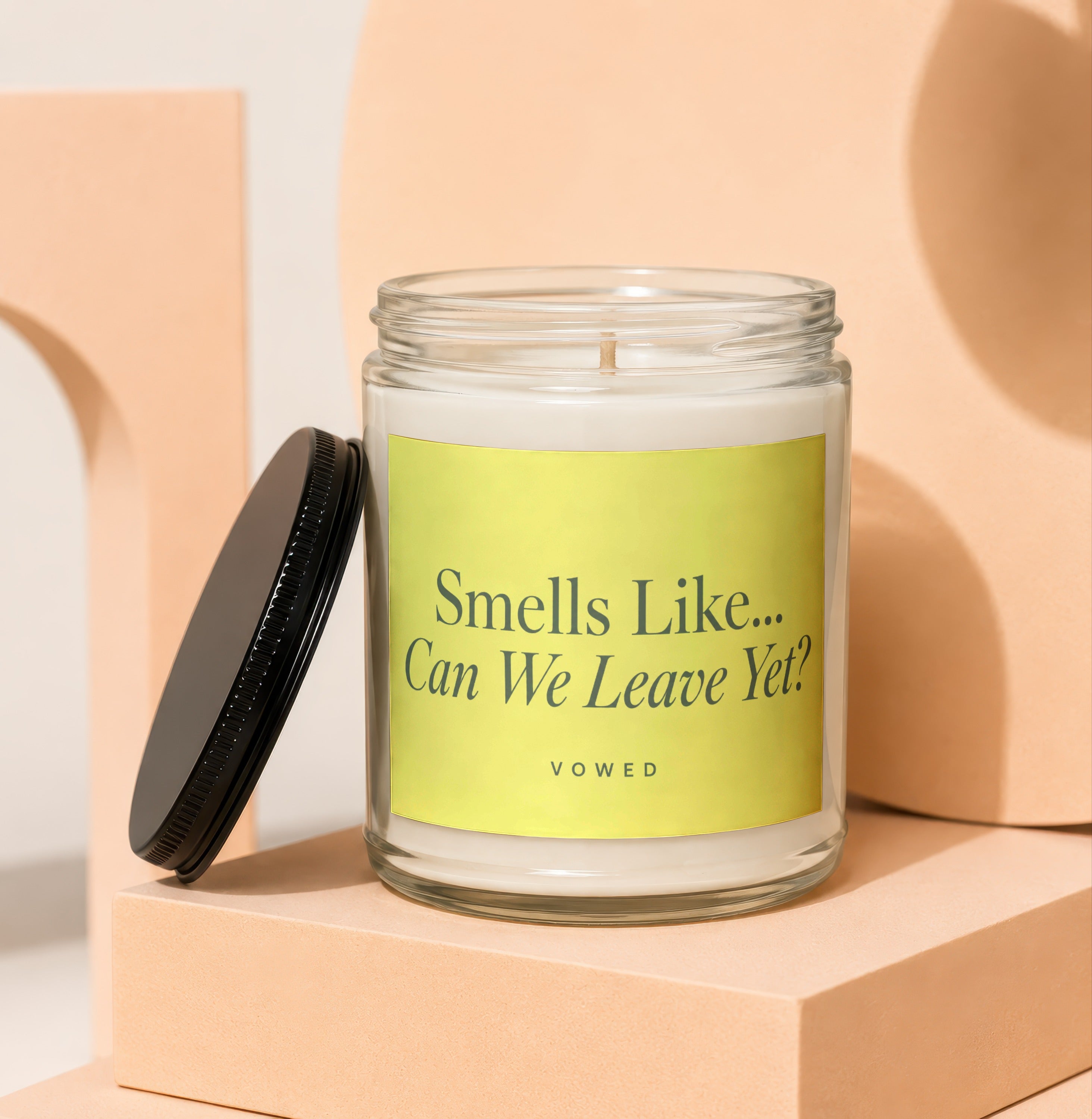 Glass candle with black lid, yellow label reads "Smells Like... Can We Leave Yet?"