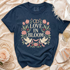 Navy t-shirt with floral and dove graphic, reading "Love in Bloom".