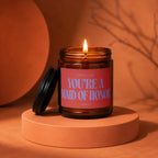 Amber jar candle with lit flame, reads "Smells Like You're A Maid Of Honor".