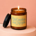 Amber jar candle with lit wick, featuring "Our person, our people" text.