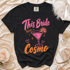Black t-shirt with "This Bride Needs a Cosmo" text and martini graphic.