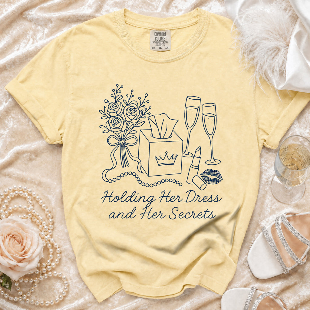 Yellow t-shirt with embroidered roses, tissue box, champagne glasses, lipstick, and text.