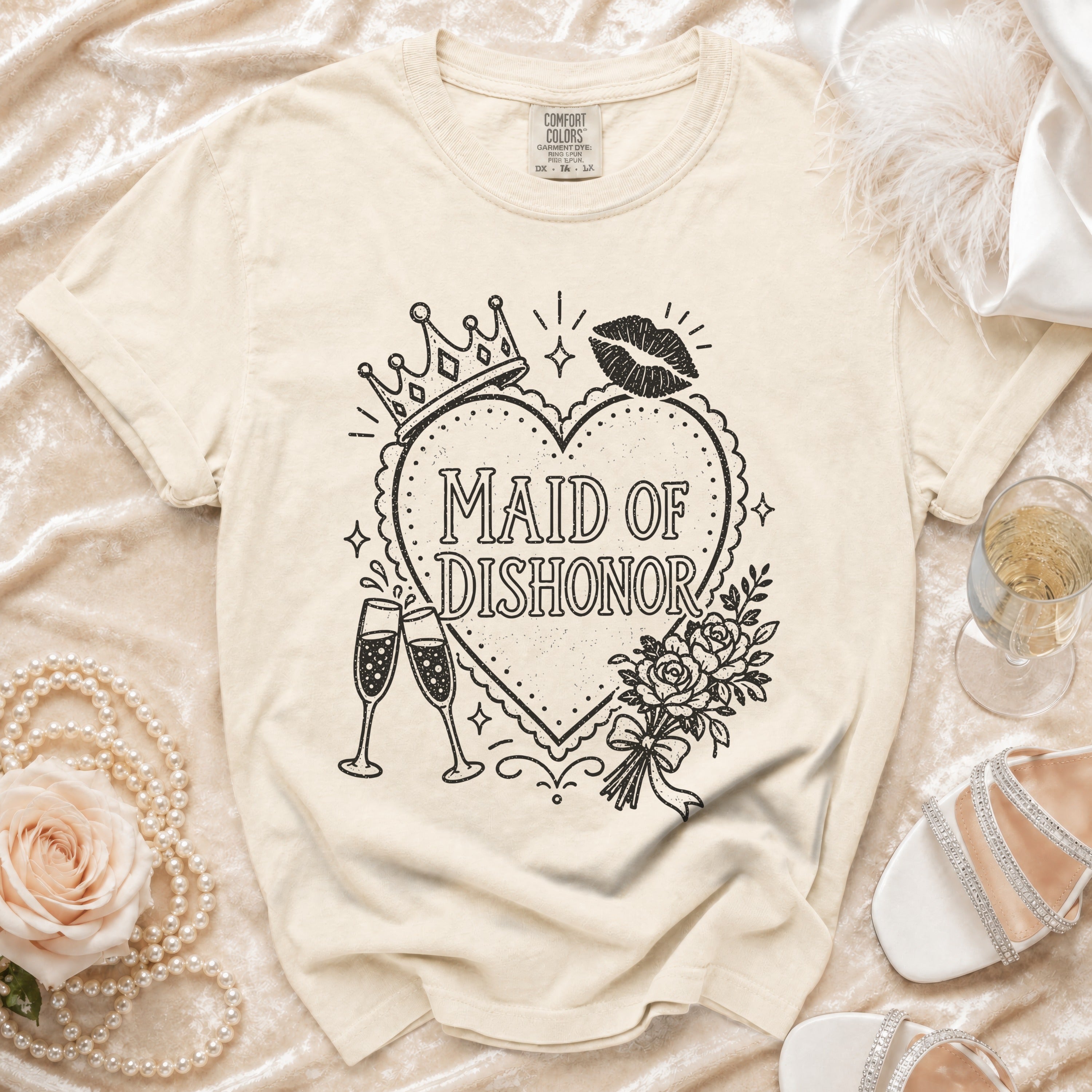 Cream t-shirt with "Maid of Dishonor" text, crown, lipstick kiss, and flowers.