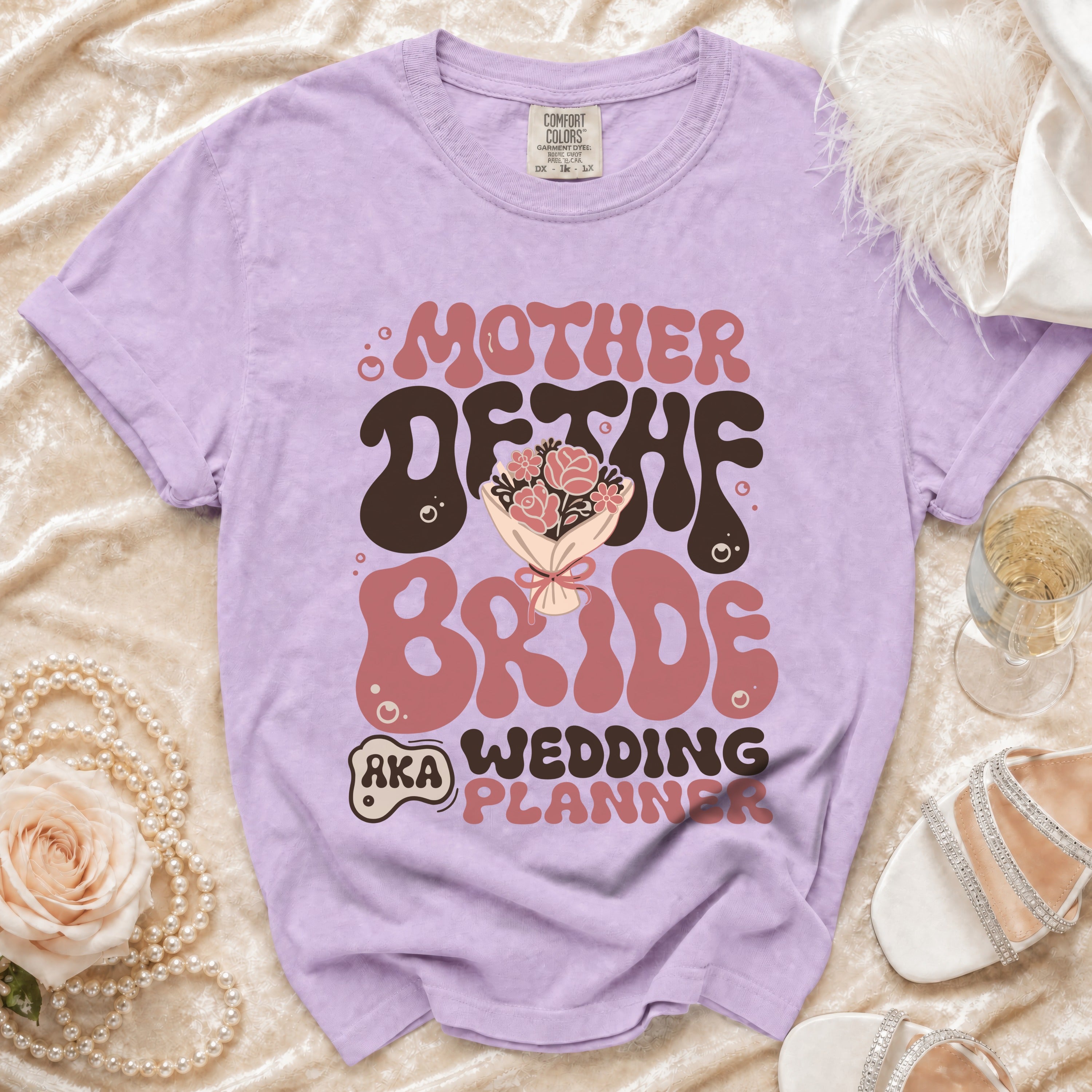 Purple t-shirt with "Mother of the Bride AKA Wedding Planner" graphic.